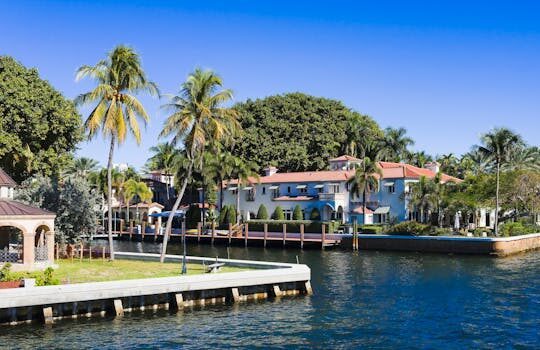 pexels-photo-15334546-15334546 Beautiful tropical homes along a canal with palm trees and clear blue sky in Fort Lauderdale, Florida.